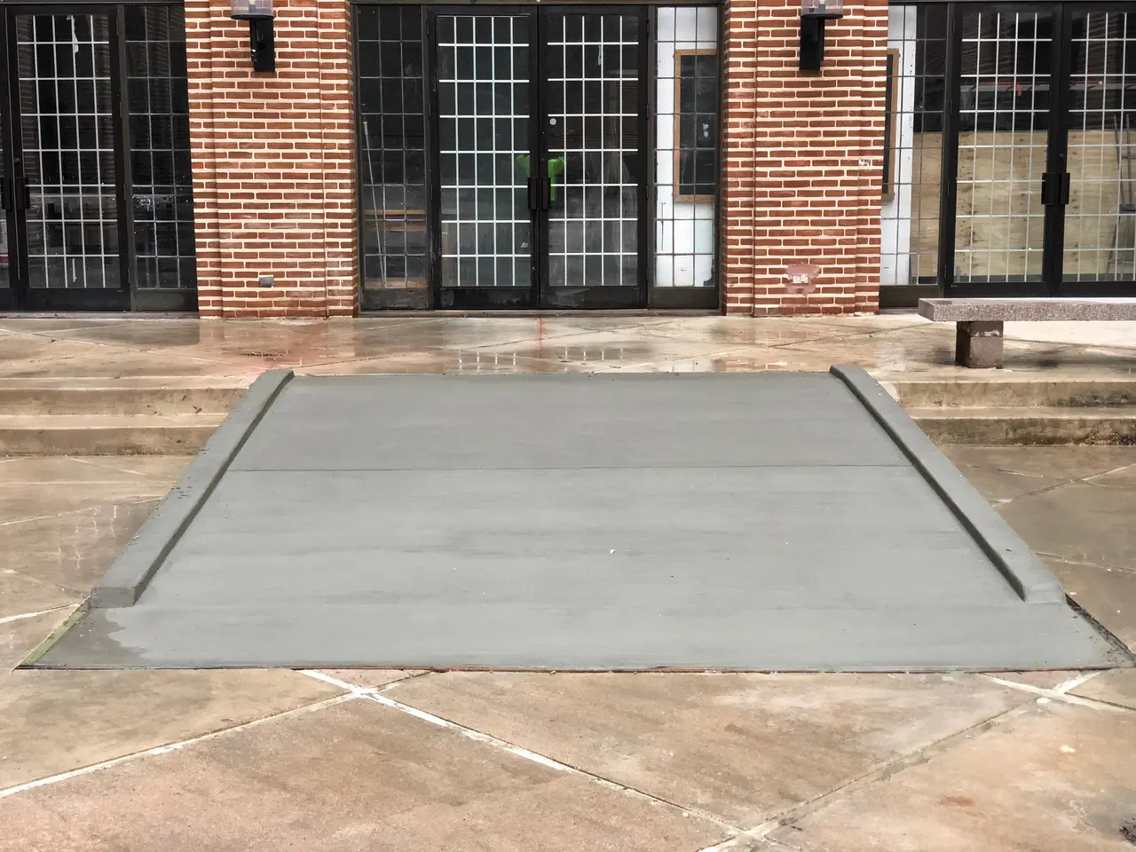 Commercial concrete flatwork pad at a brick building